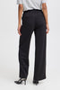 A model shown from the back wearing black wide-leg trousers with an elastic waistband, paired with a light gray t-shirt and black high heels, against a plain white studio background.