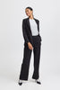 Woman wearing a black suit with a white shirt on a white background